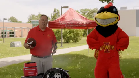 Vice President Jason Henderson and Cy the ISU mascot grilling out.