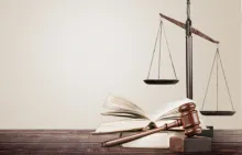 gavel and lawbook with scales of justice in the background